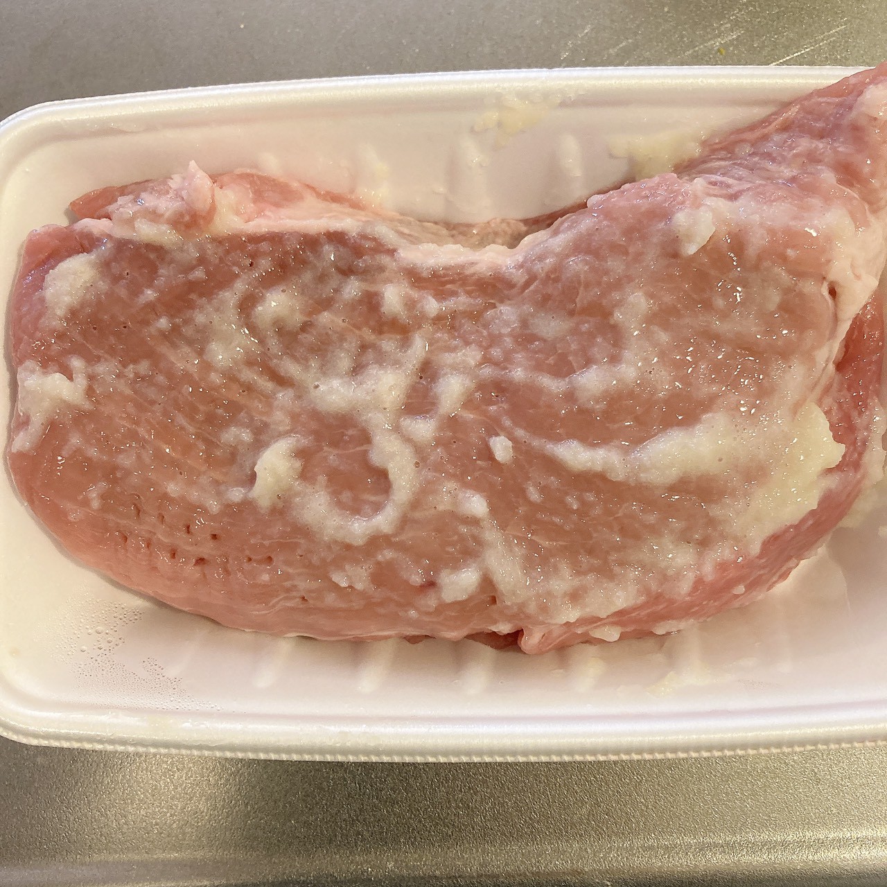 塊肉に調味料とにんにくが塗られている