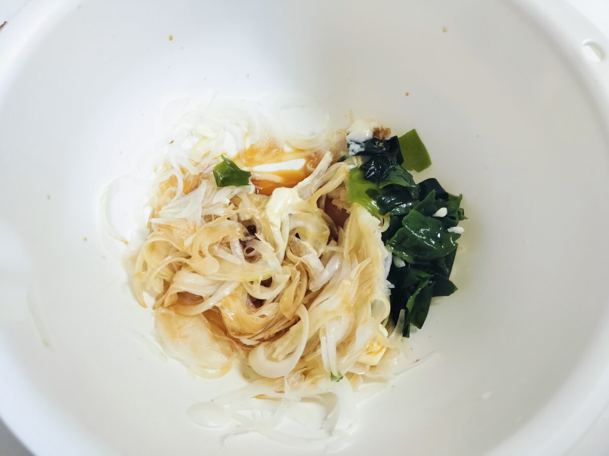 わかめと玉ねぎと調味料を混ぜる様子