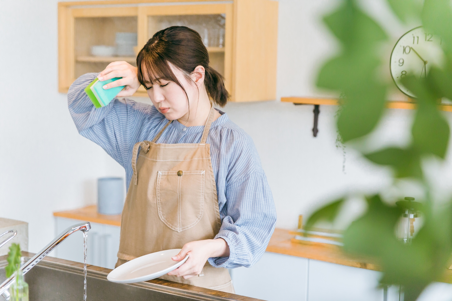 しんどそうに洗い物をしている女性