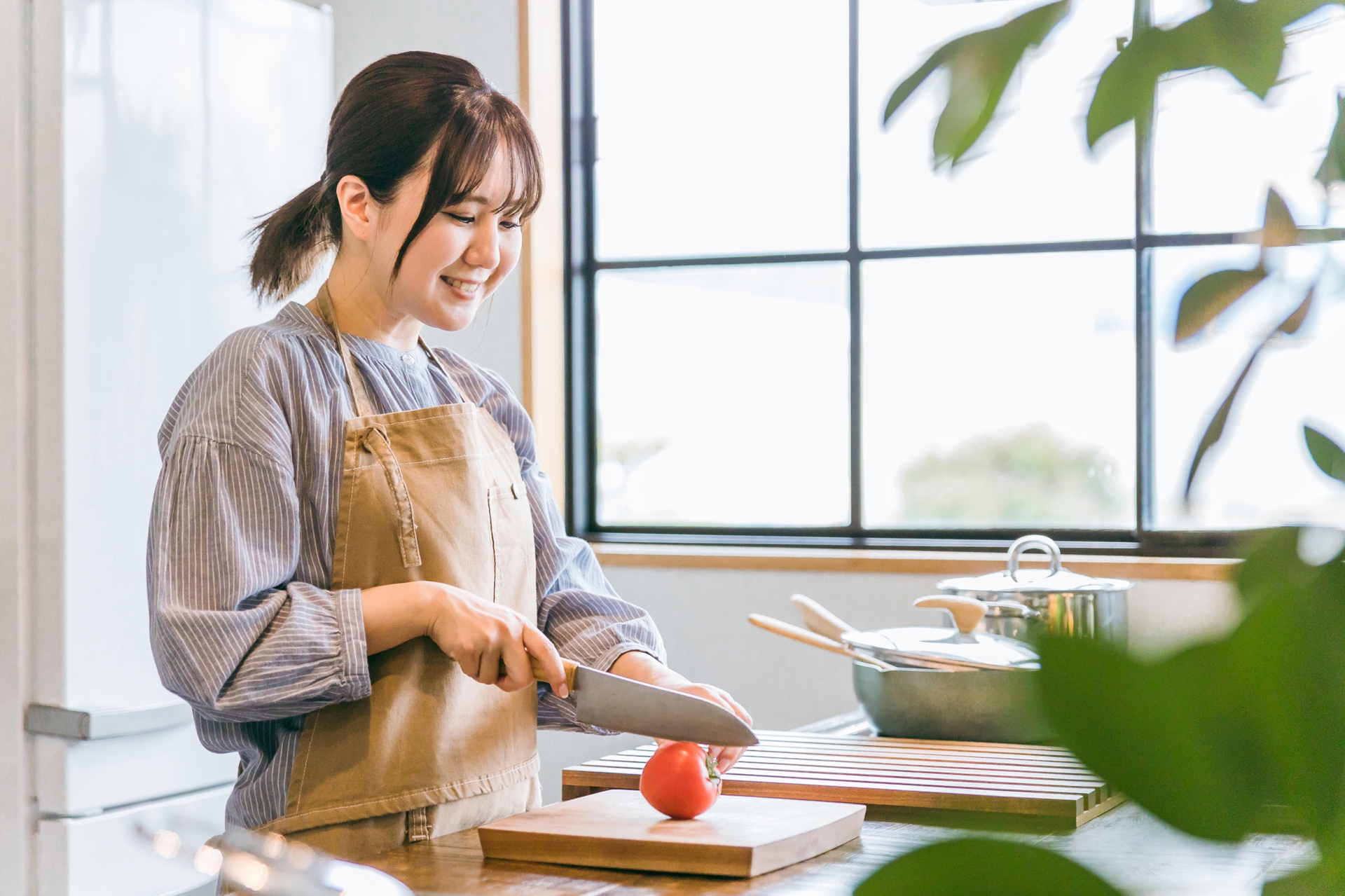 キッチンで野菜を切る女性