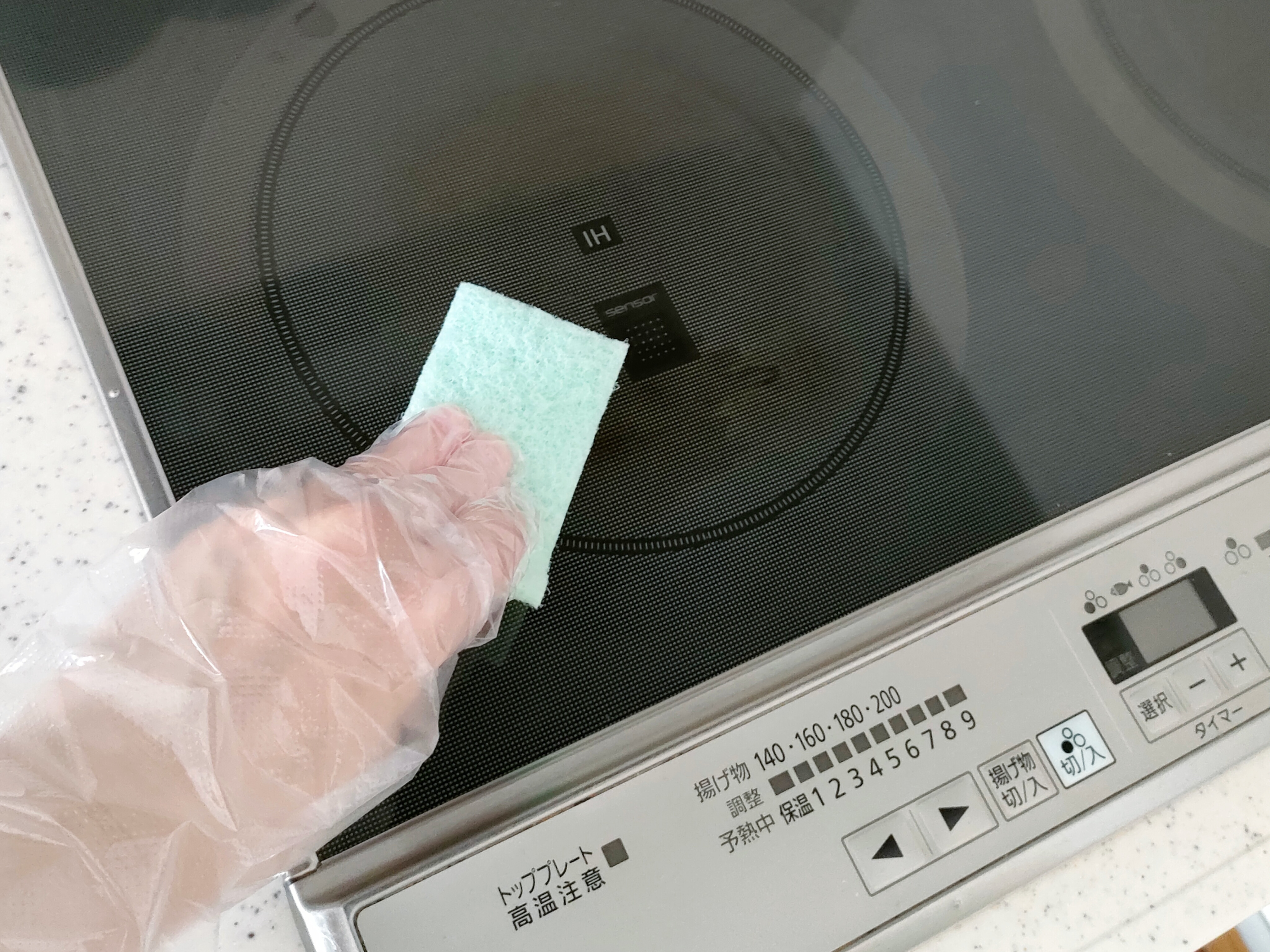 コンロの汚れを落としている
