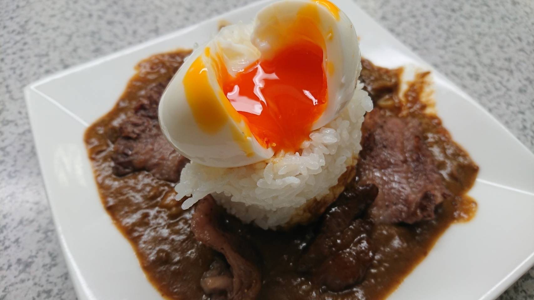牛筋カレーに卵がのっている