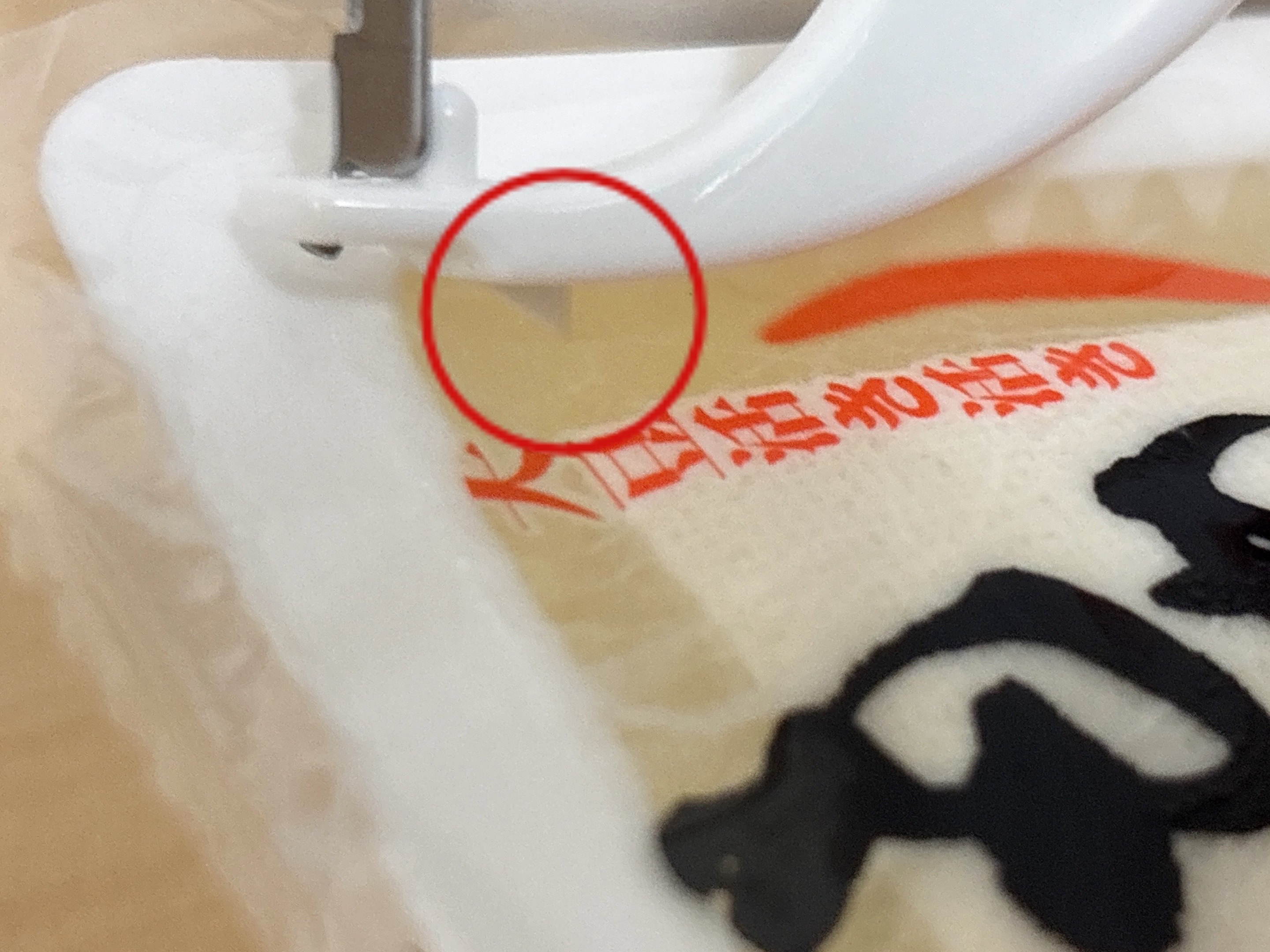 ピーラーのカッター部分で豆腐パックを開けている様子
