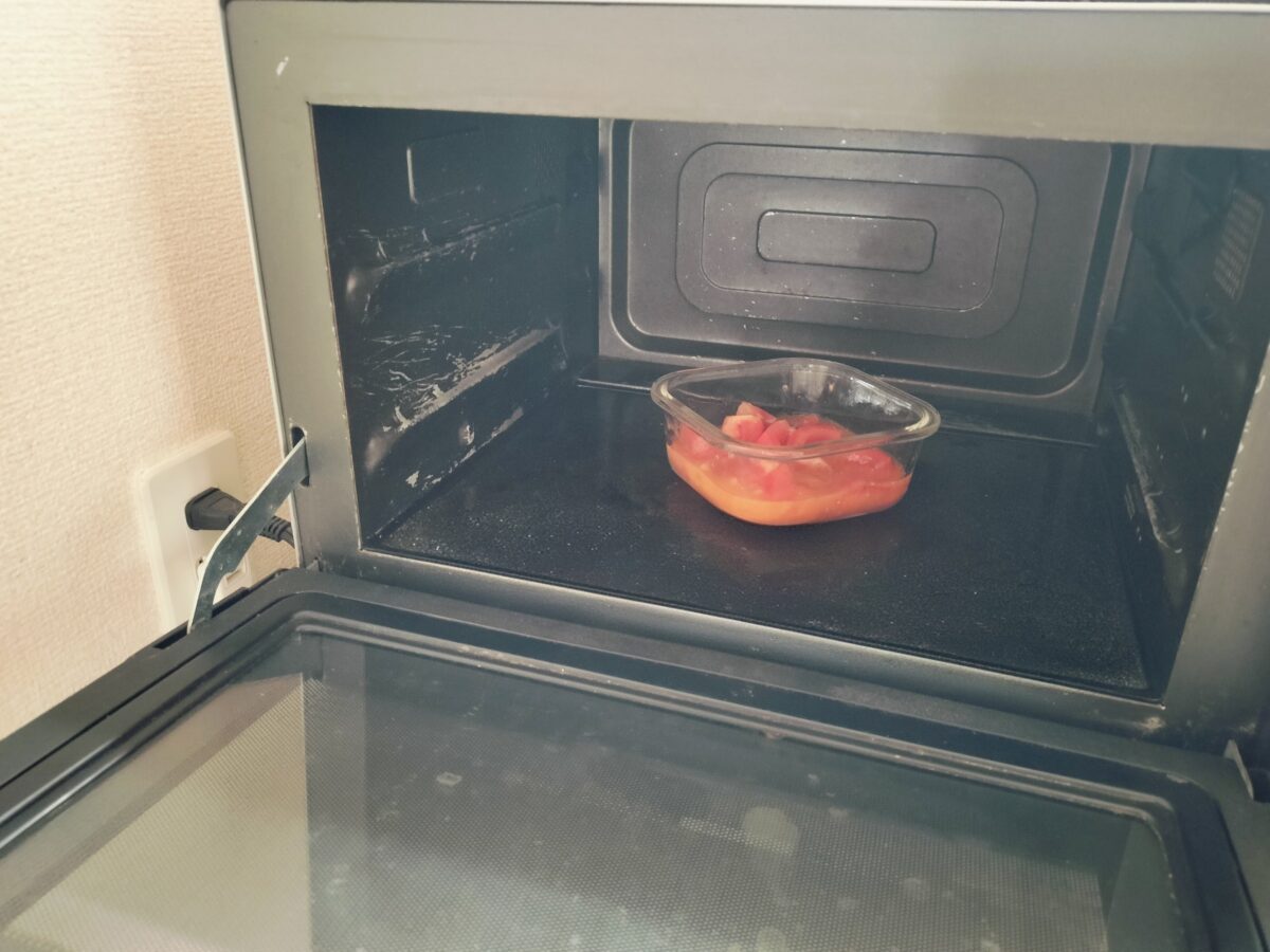 電子レンジで加熱するトマトのはいった容器