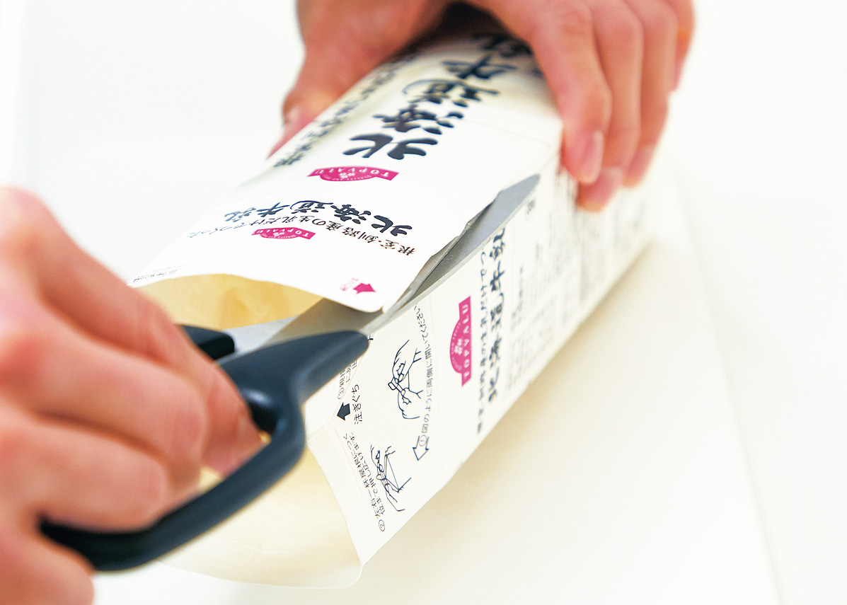 牛乳パックをハサミでカットしている様子