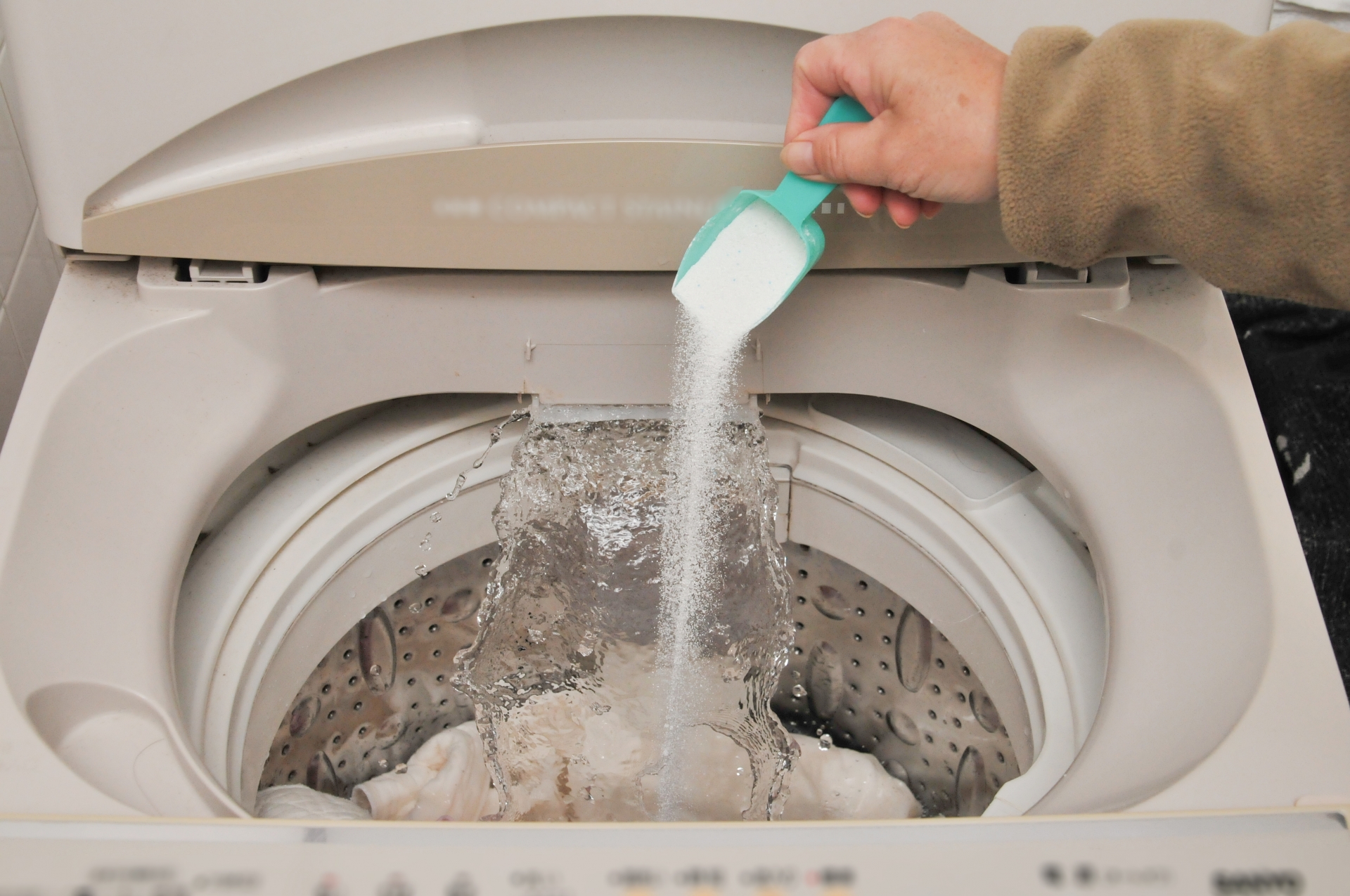 洗濯機に洗剤を入れる