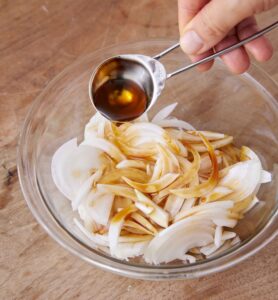 玉ねぎに味つけしている様子