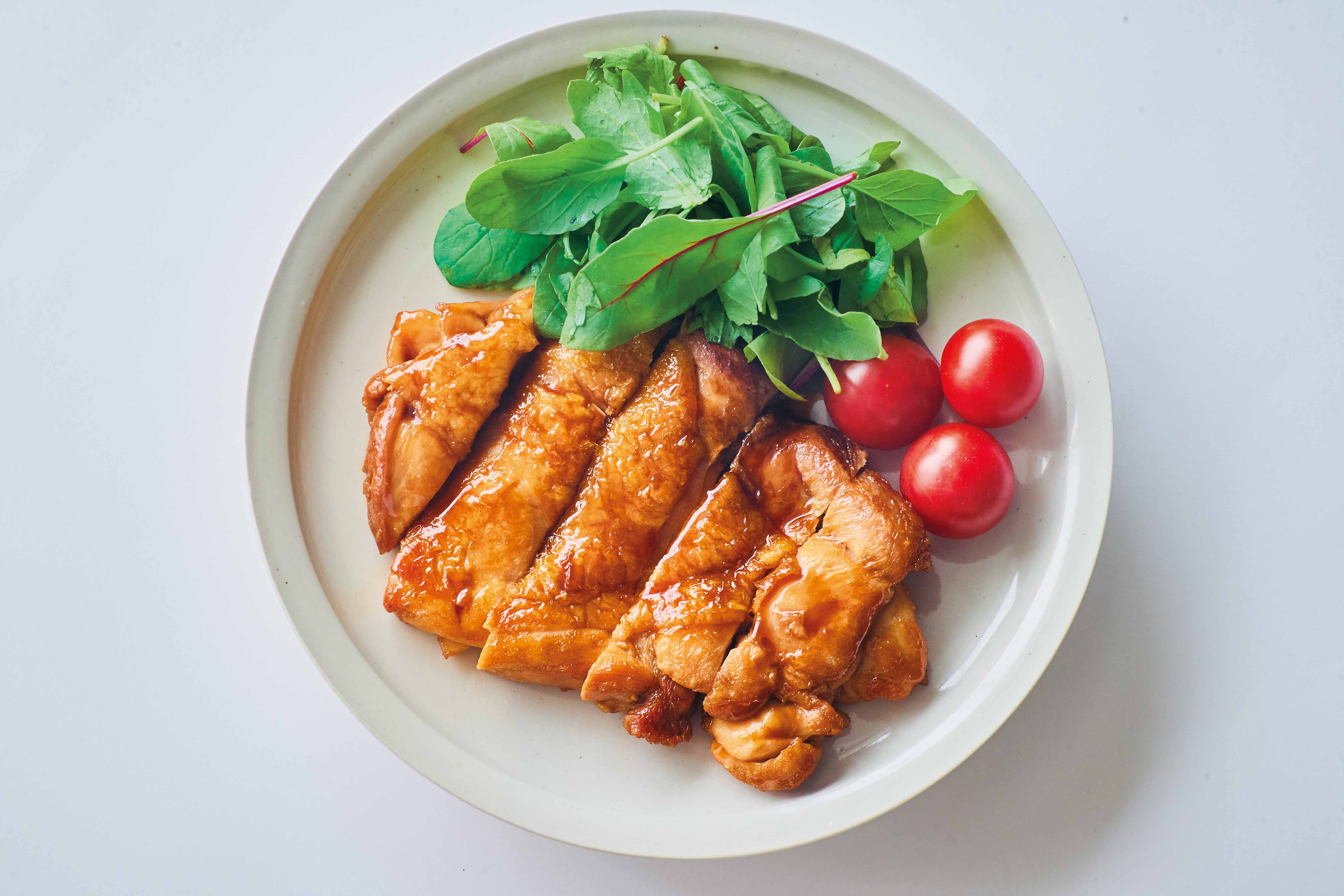 エバラ「すき焼のたれ」で作った甘旨チキンとベビーリーフ、ミニトマトを盛りつけた皿
