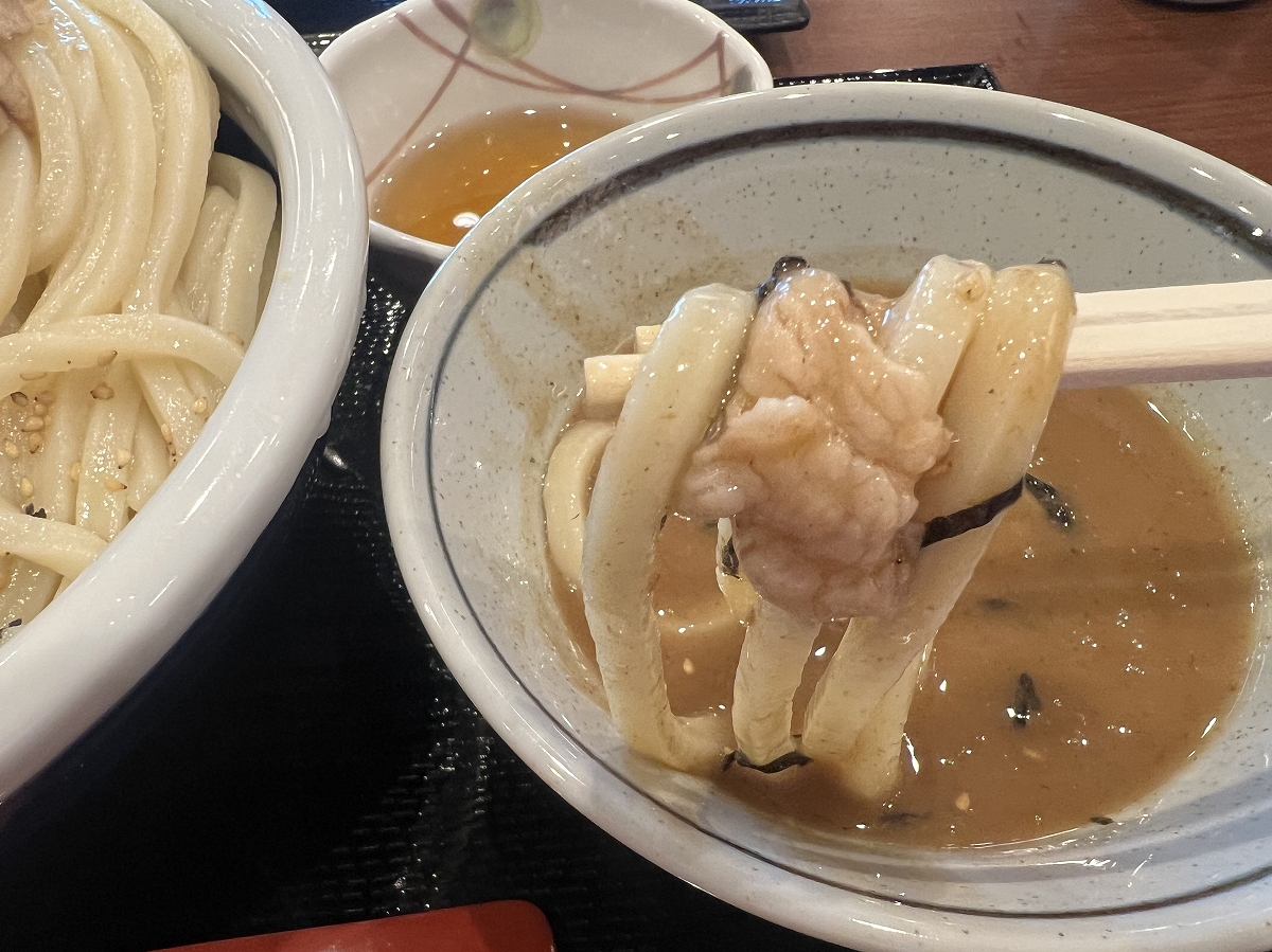 「濃厚魚介豚つけ汁うどん」のつけ汁にうどんをつけているところ