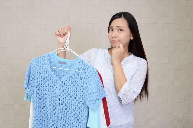 服をみて悩む女性