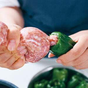 肉だねをピーマンに絞り出している様子