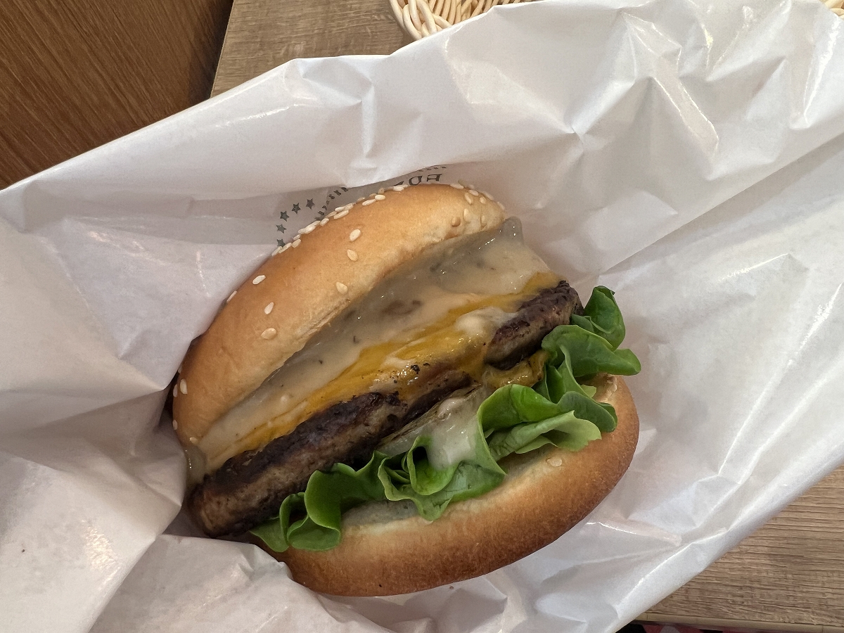 「マッシュルームチーズバーガー ポルチーニクリームソース」を手で持ったところ