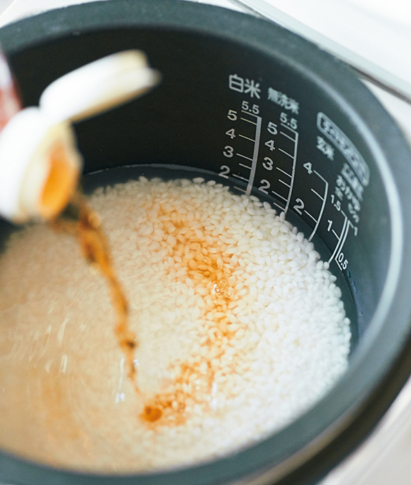 炊飯器に白だしを入れている様子