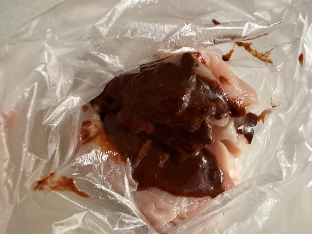 ケイジャンチキンの素で鶏肉に味付ける様子