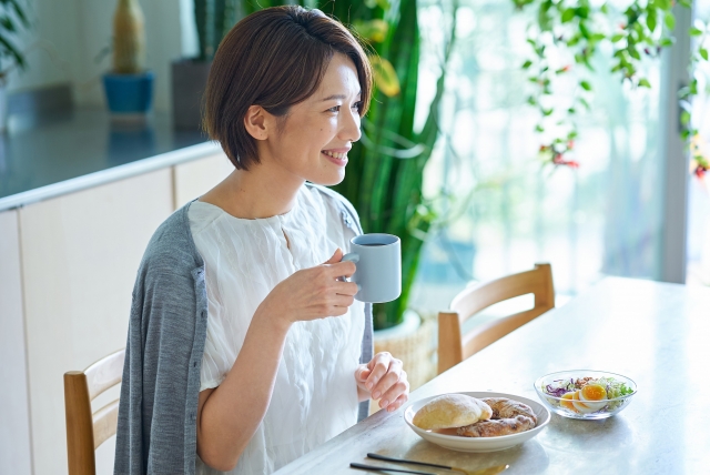 おしゃれな部屋で朝食を食べる女性