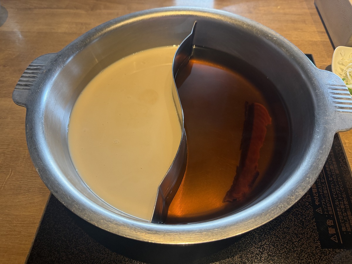 「豆乳ポルチーニしゃぶしゃぶ」と「鴨しゃぶ」のだしが入った鍋